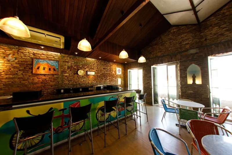 Café da Casa da Ribeira com balcão pintado à mão e paredes de tijolo aparente, case HOUSECULTURA
