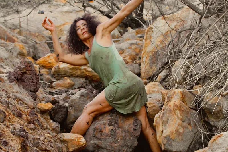 Bailarina de vestido verde em pose sobre as pedras da nascente do Rio Potengi, curta Renascente da HOUSECULTURA