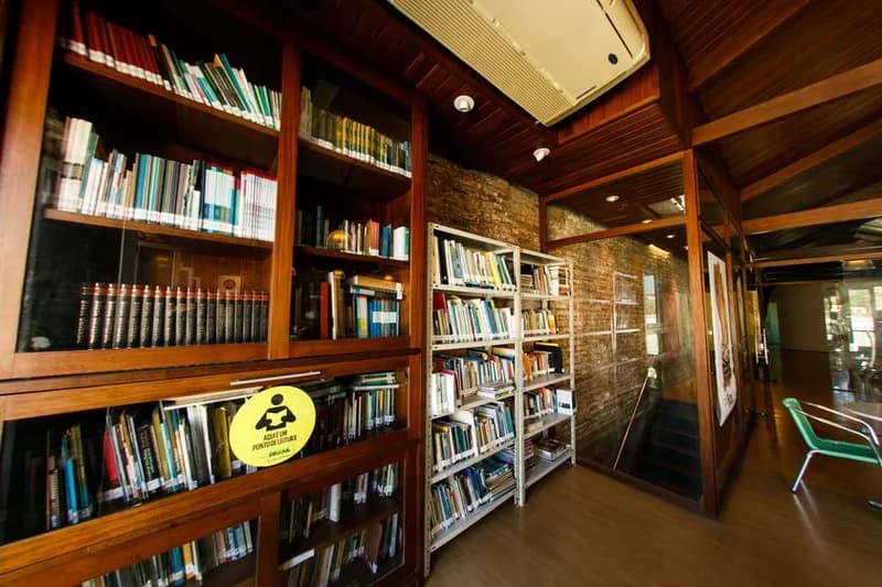 Biblioteca da Casa da Ribeira com estantes de madeira e acervo de teatro, case HOUSECULTURA
