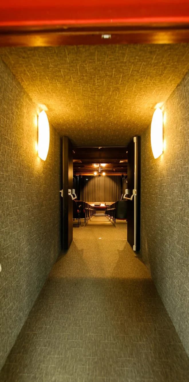 Corredor iluminado da Casa da Ribeira levando à sala de espetáculos, projeto HOUSECULTURA em Natal